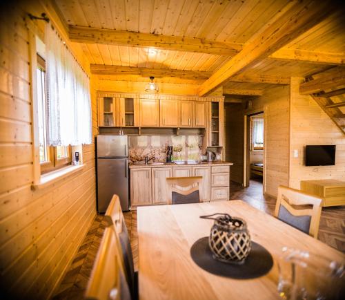 una cocina con mesa en una cabaña en Kraina Dauby, en Wielowieś