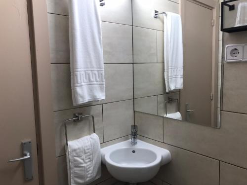 a bathroom with a sink and a mirror and towels at Hostal Radio Barcelona in Barcelona