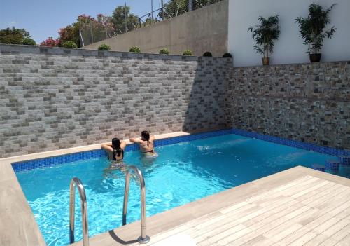 Dos personas están en una piscina en Apartmentos Corona, en Cazorla