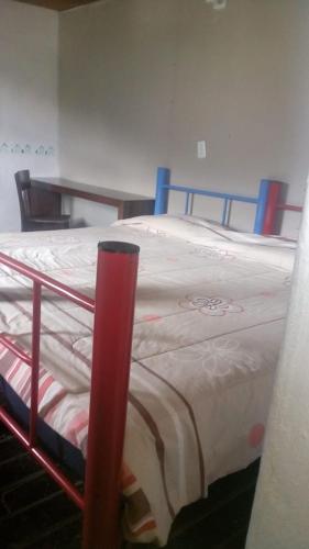 a bed with a red pole in a room at Posada Santa María in Mineral del Chico