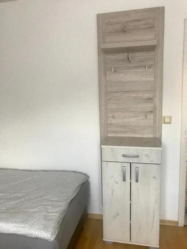 a bedroom with a bed and a wooden cabinet at JUNA in Karlsruhe