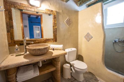 a bathroom with a sink and a toilet and a mirror at Elpiniki in Alinda