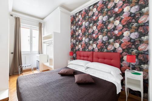 a bedroom with a red headboard and a floral wallpaper at Persia Collection Trevi in Rome