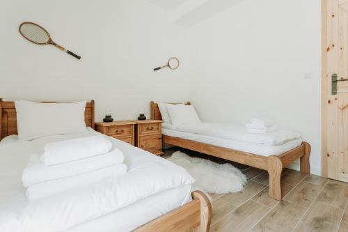 a bedroom with two beds with white sheets at Apartament JODEŁKA in Szczyrk