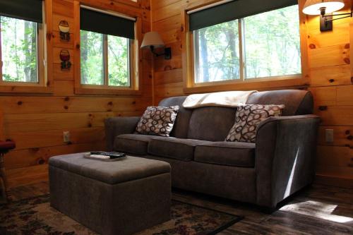 a living room with a couch and a stool at Country Road Cabins in Hico