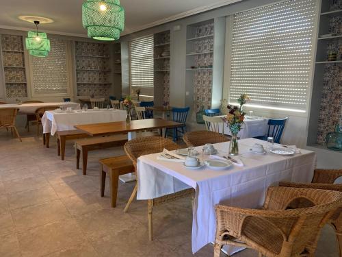 une salle à manger avec tables, chaises et fenêtres dans l'établissement Hotel O'Pazo, à Vigo