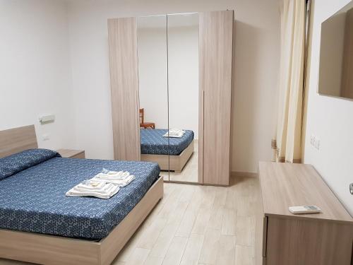 a bedroom with two beds and a mirror at La casa di Laura in Tortolì