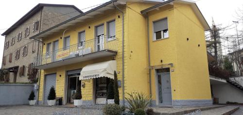 - un bâtiment jaune avec un balcon au-dessus dans l'établissement Bed and Breakfast lo Scrigno, à Polinago