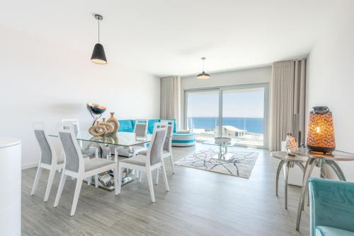 a dining room with a table and chairs and the ocean at Getaway to Blue Paradise at Madeira Island in Funchal