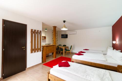 a bedroom with two beds and a dining room at Airport Károly Centrál in Vecsés