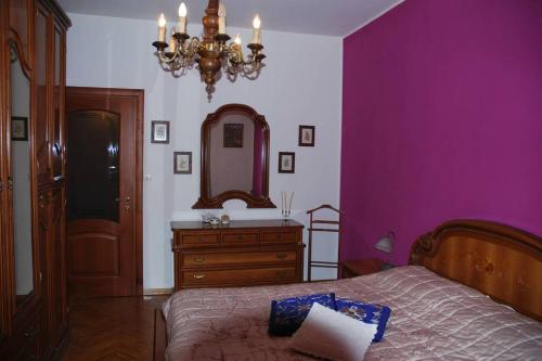 a bedroom with purple walls and a bed and a mirror at GRAZIOSO APPARTAMENTO IN ZONA SANTA RITA in Turin