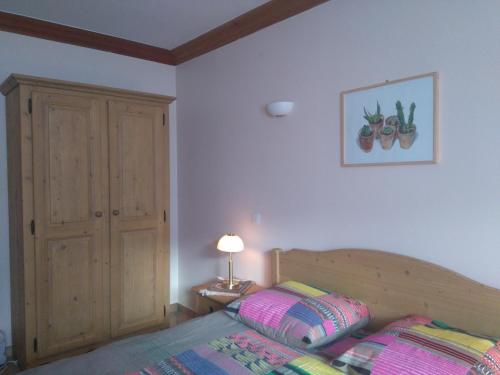 - une chambre avec un lit et une photo de fruits sur le mur dans l'établissement L'Embrune, à Tignes