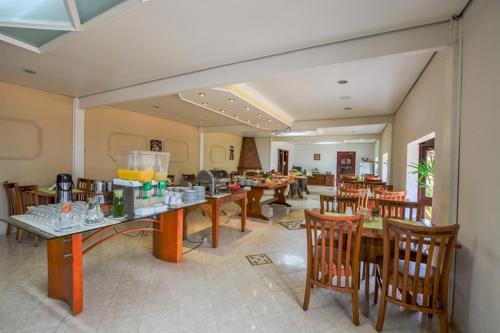 uma sala de jantar com mesas e cadeiras e uma sala cheia de em Pousada Monte Silvestre em Monte Verde