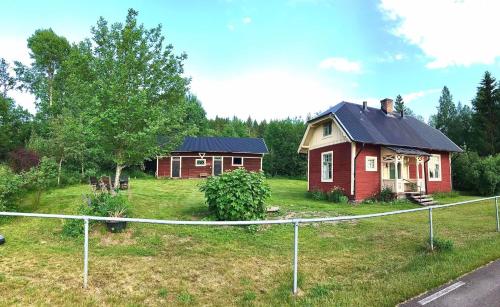 two small houses in a yard with a fence at Holsby banvaktarstuga in Ransäter