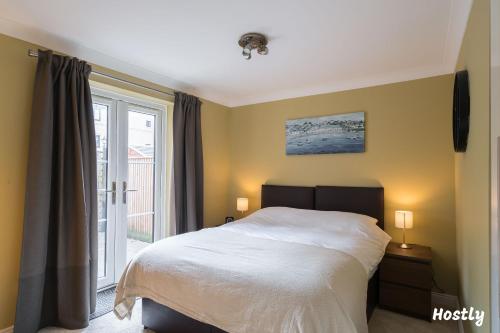 a bedroom with a white bed and a window at Swan Place - Comfortable Home in Reading