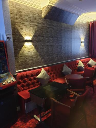 a room with a red couch and a brick wall at Langroyd Hotel in Blackpool