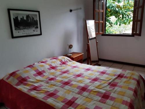 a bedroom with a bed with a checkered blanket at CASA DE PRAIA DO PERÓ in Cabo Frio