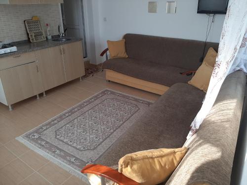 a living room with a couch and a kitchen at Elite Apart Pansiyon in Gokceada Town