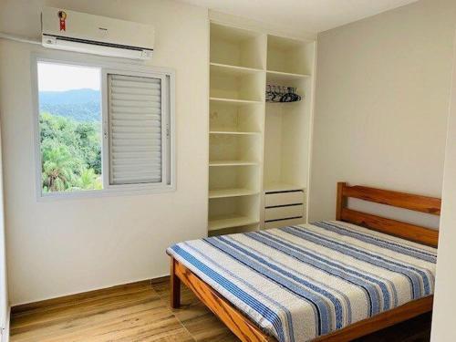 - une chambre avec un lit et une fenêtre dans l'établissement Apto Completo C/Ar, Varanda Gourmet e Piscina, à Ubatuba