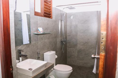 a bathroom with a toilet and a sink and a shower at Seafood Restaurant and Motel in Tangalle