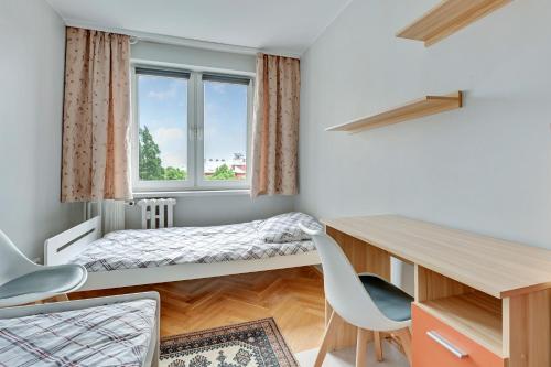 グダニスクにあるApartament Alicja IIのベッドとデスクが備わる小さな客室です。