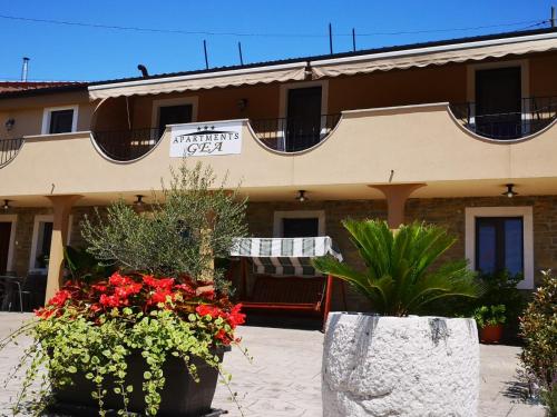 a hotel with flowers in front of a building at Apartments Gea in Lucija