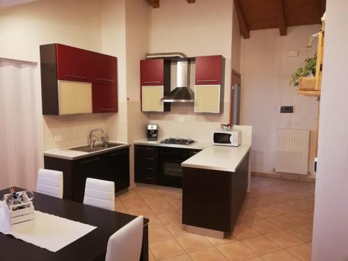 una cucina con armadi rossi e piano di lavoro nero di Casa Vacanze Gaia a Cividale del Friuli