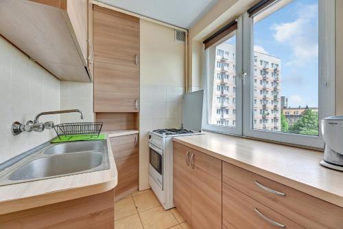 eine kleine Küche mit einem Waschbecken und einem Fenster in der Unterkunft Apartament Alicja II in Danzig