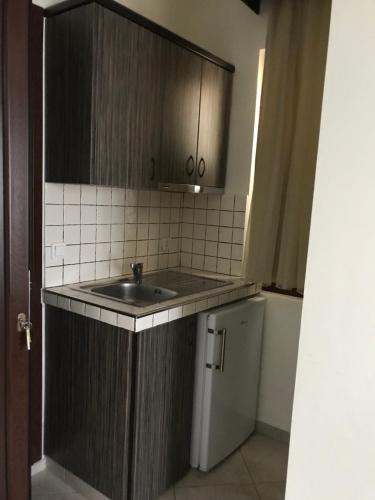 a small kitchen with a sink and a refrigerator at Makedos Sea View in Nea Vrasna