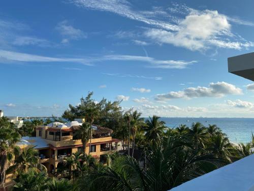 a view of a building with the ocean in the background at Cuxos Hotel Beachfront in Isla Mujeres