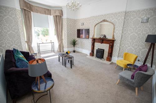 a living room with a couch and a fireplace at Lynwood House in Southport