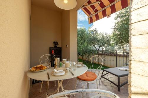 a patio with a white table and chairs on a balcony at Apartments Nono in Poreč