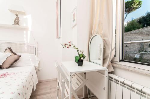 a small white bedroom with a bed and a mirror at My Bed Vatican Museum in Rome