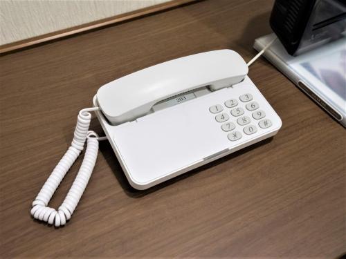 a white phone sitting on top of a desk at SHIN YOKOHAMA SK HOTEL - Non Smoking - Vacation STAY 86111 in Yokohama