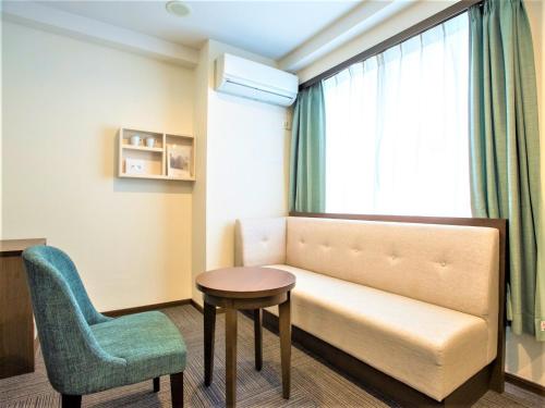 a room with a couch and a chair and a table at SHIN YOKOHAMA SK HOTEL - Non Smoking - Vacation STAY 86111 in Yokohama