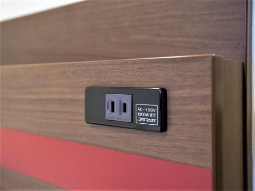 a digital clock sitting on top of a wooden box at SHIN YOKOHAMA SK HOTEL - Non Smoking - Vacation STAY 86111 in Yokohama