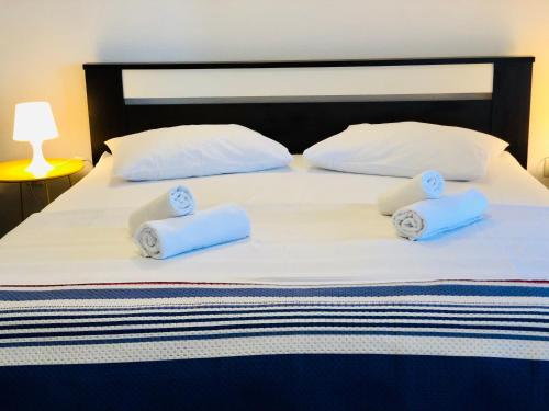 a bed with white pillows and blue towels on it at Guest House Stipe in Brela