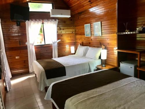 a bedroom with two beds and a window at Cabañas Agua Dulce in Providencia