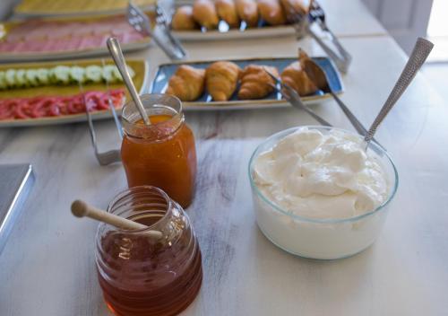 a table with two jars of honey and a plate of pastries at Niriides Hotel Apartments in Symi