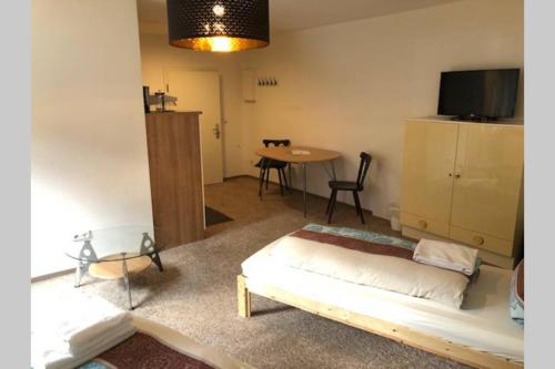 Schlafzimmer mit einem Bett, einem Tisch und einem TV in der Unterkunft MühlwegAppartment 2 in Alzenau in Unterfranken