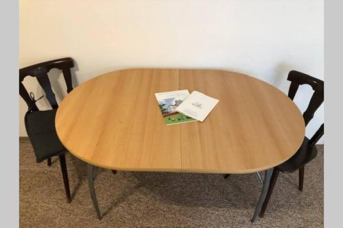 einem Holztisch mit zwei Stühlen und einem Buch darauf in der Unterkunft MühlwegAppartment 2 in Alzenau in Unterfranken