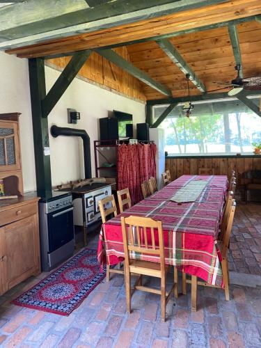 een eetkamer met een tafel en stoelen in een keuken bij Farm house in Domaszék