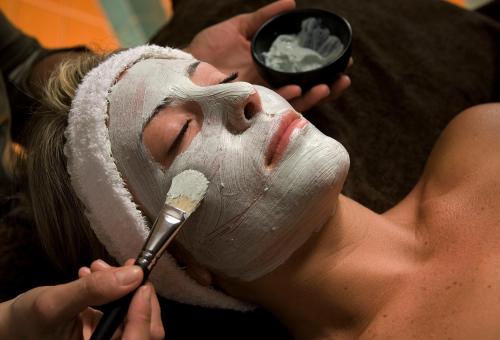 a woman with a mask on her face with a brush at Hotel Mare Blu Terme in Ischia