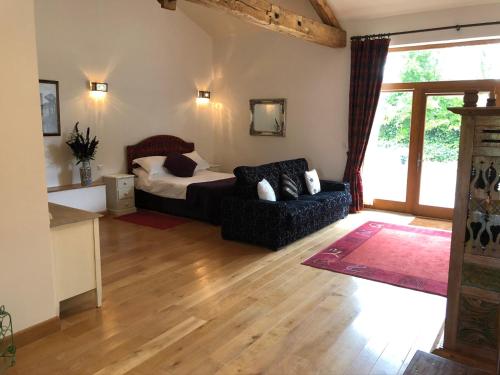 un salon avec un lit et un canapé dans l'établissement L`Atelier, à Saint-Martial-Viveyrol