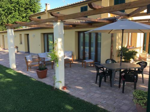 a patio with a table and chairs and an umbrella at Podere Gabry in Arena Metato