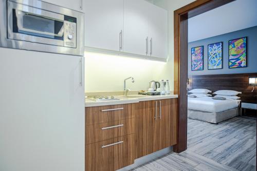 a kitchen with a sink and a bed in a room at Hafawah Suites in Al Madinah