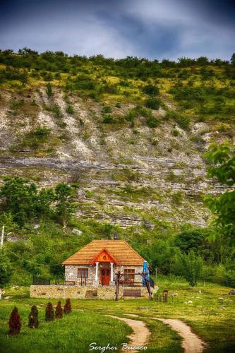 a small house in front of a mountain at Casa Agricultorului Varzari in Butuceni