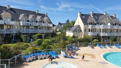 un complexe avec une piscine et des personnes sur la plage dans l'établissement Vacances Ô Cap Coz - Jardin vue mer et piscine - Résidence Cap Azur Fouesnant, à Fouesnant