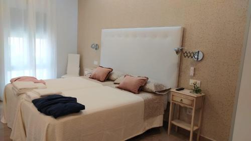 a small bedroom with a bed and a night stand at Casa Rural Albahaca in Herrera del Duque