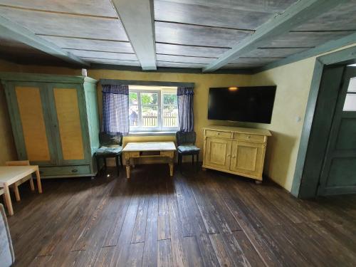 a room with a tv and a table and chairs at Chalupa Království in Šluknov